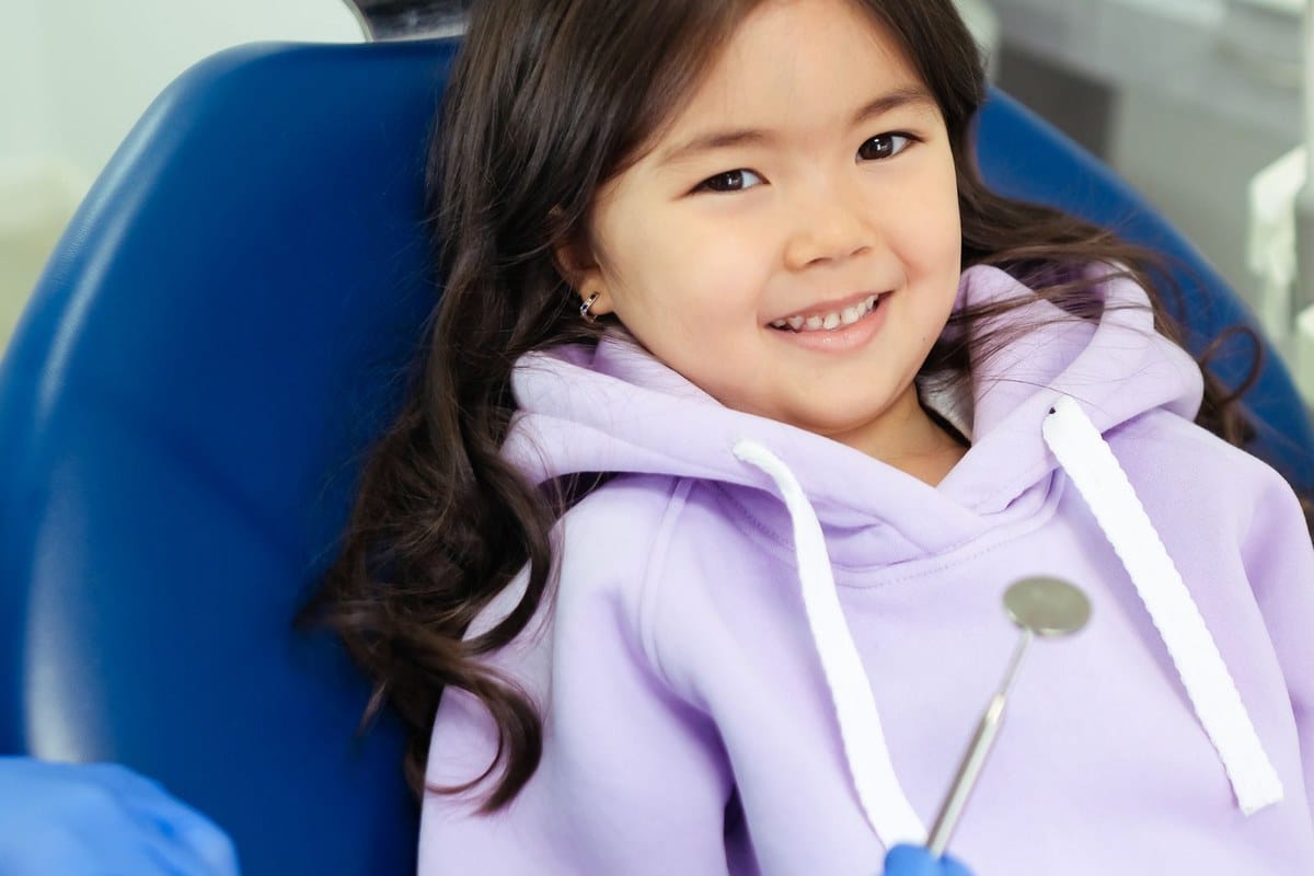 Enfant souriant lors d'une consultation dentaire de contrôle