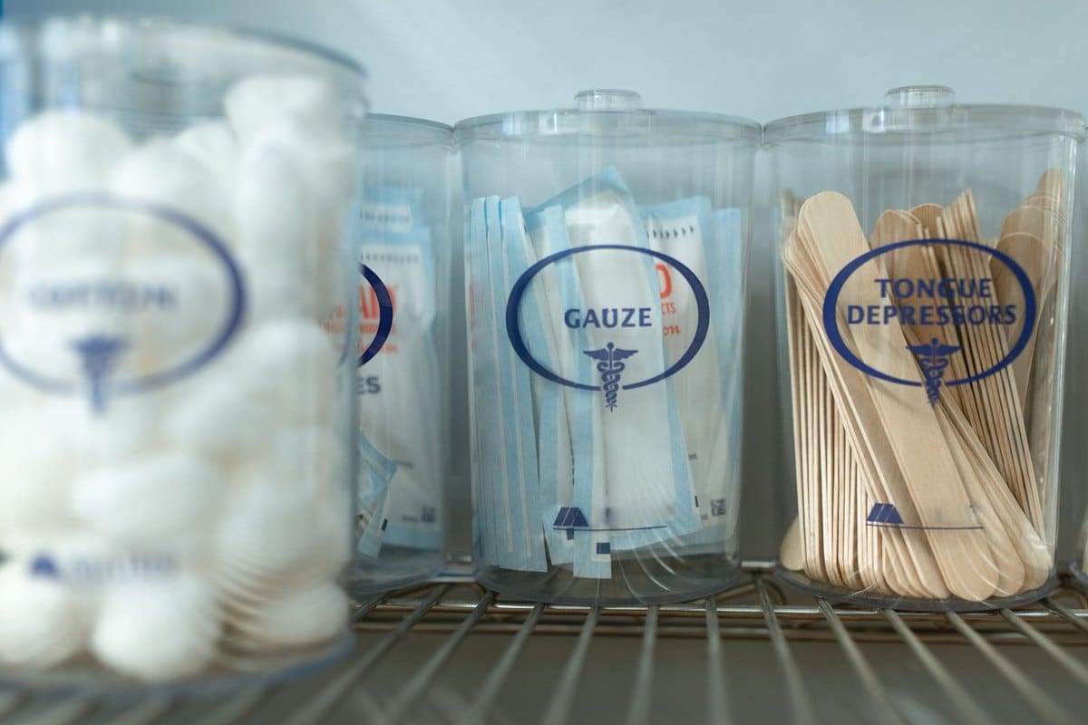 Bocaux de compresses et de cotons sur une étagère de matériel de soin