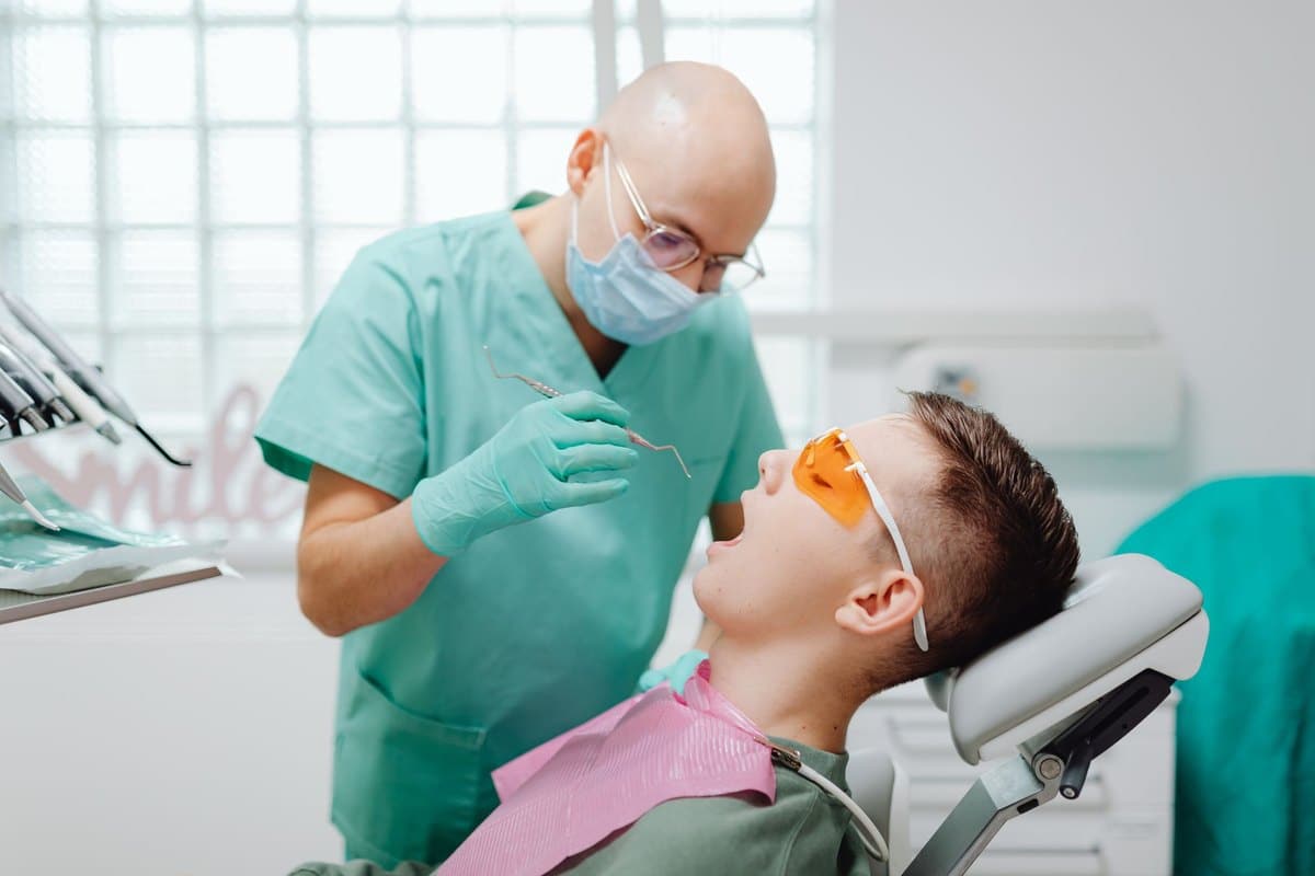 Praticien examinant la bouche d'un patient installé au fauteuil